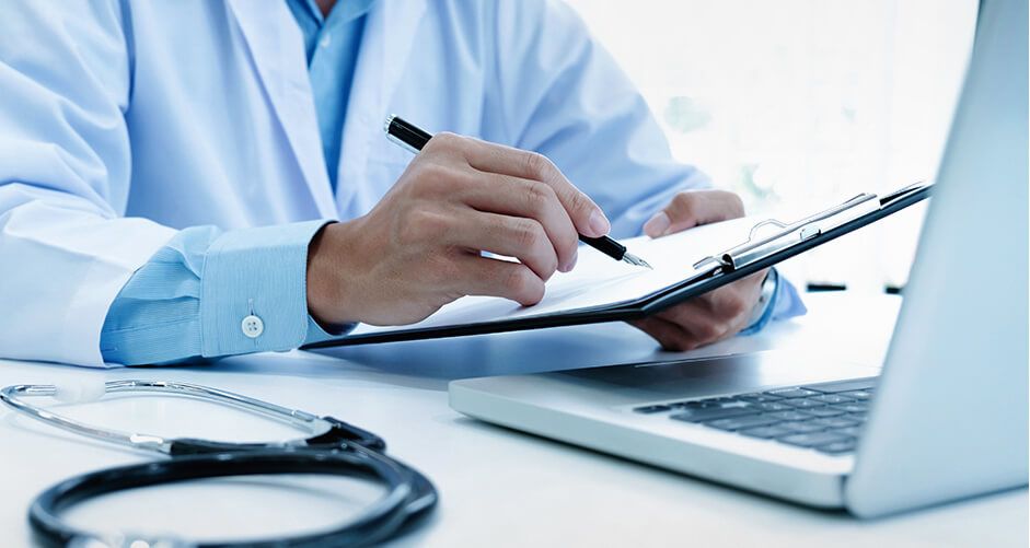 A doctor working on a laptop